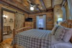 Main Floor Master Bedroom with a Queen Bed, a Flat Screen TV with a Barn Door to the Bathroom 